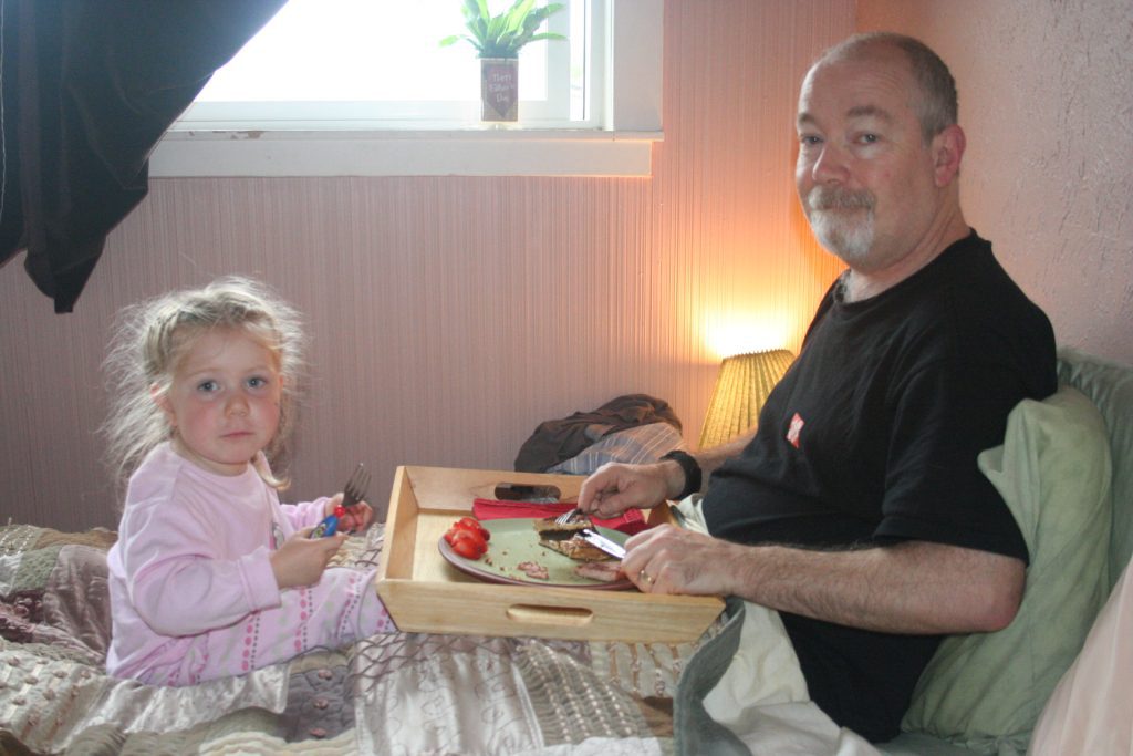 Sharing breakfast in bed with my girl-best gifts for dad on Father's Day