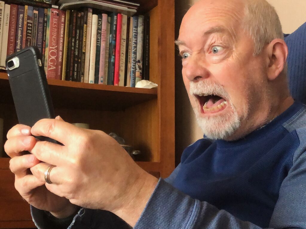 looking for connection-angry Facebook user on his phone